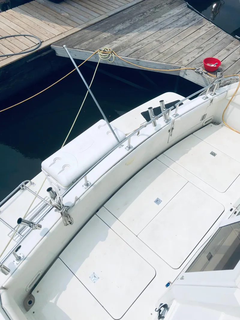 Slide: The Image of 1994 Carver 430 Cockpit Motor Yacht docked, featuring spacious deck and seating area. - 2