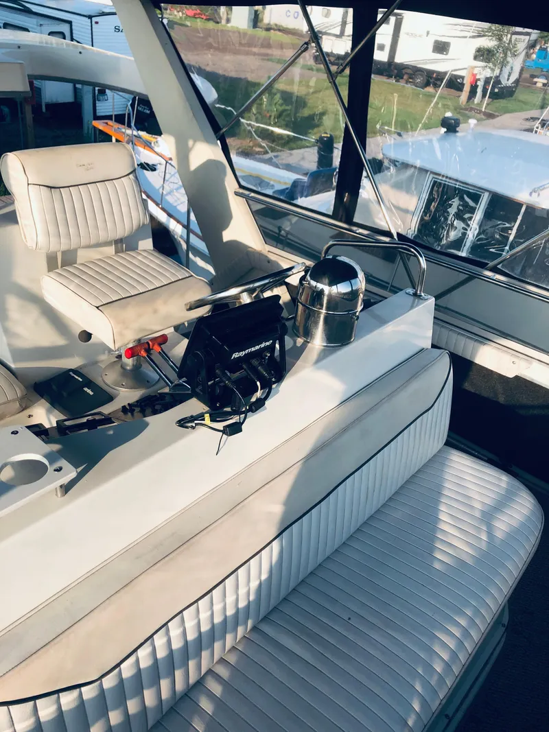 Slide: The Image of 1994 Carver 430 Cockpit Motor Yacht interior with white seating and control panel. - 4