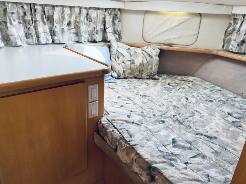 Slide: The Image of 1994 Carver 430 Cockpit Motor Yacht interior with patterned bedding and wooden cabinetry. - 16