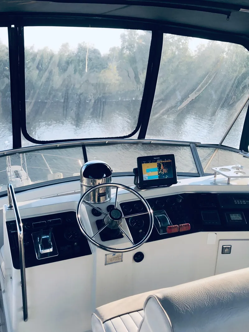 Slide: The Image of 1994 Carver 430 Cockpit Motor Yacht helm with steering wheel and navigation system. - 3