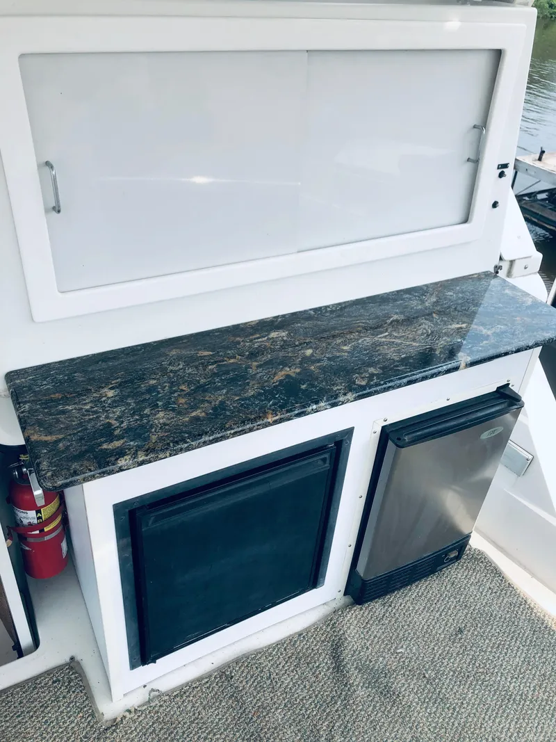 Slide: The Image of 1994 Carver 430 Cockpit Motor Yacht interior with granite countertop and mini fridge. - 6