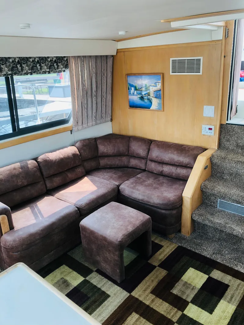 Slide: The Image of Interior of 1994 Carver 430 Cockpit Motor Yacht with brown sectional sofa and patterned carpet. - 9