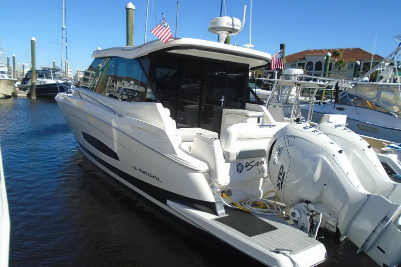 The Image of 2024 Regal 36 XO yacht docked, featuring dual outboard engines and sleek design. - 0