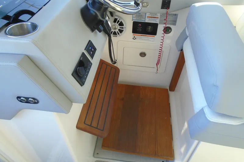 Slide: The Image of 2024 Regal 36 XO helm station with controls, speaker, and wooden footrest. - 37