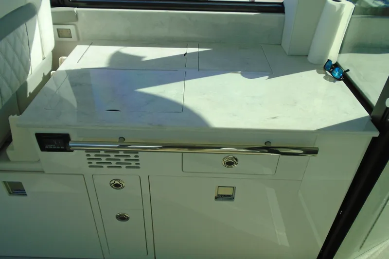 Slide: The Image of 2024 Regal 36 XO yacht interior kitchen area with sleek countertop and storage. - 39