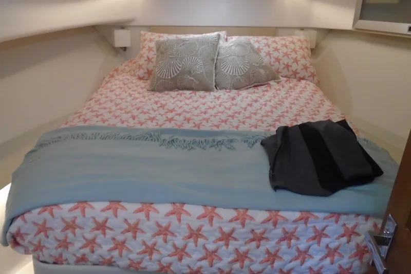 Slide: The Image of Cozy bedroom in 2024 Regal 36 XO yacht with starfish bedding and decorative pillows. - 40