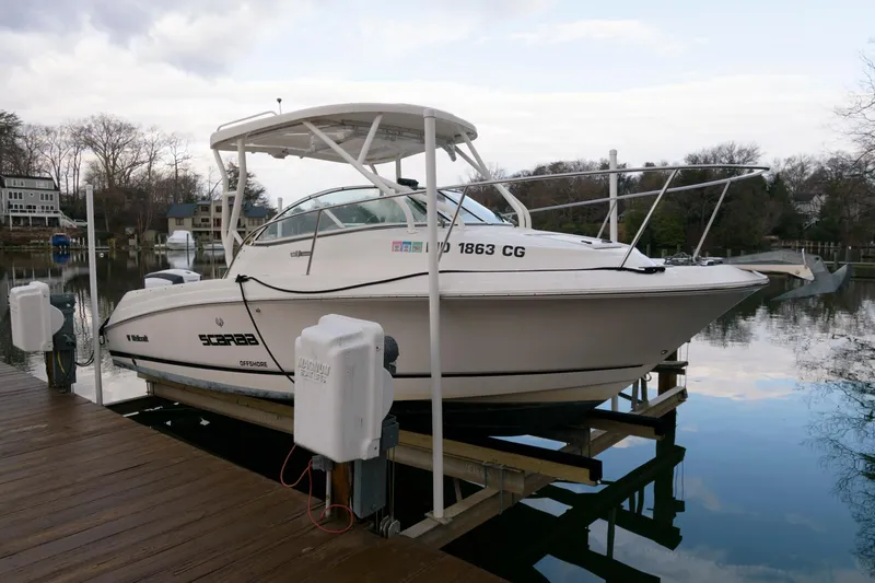 Slide: The Image of 2016 Wellcraft 232 Coastal boat docked on a lift by a calm lake. - 2