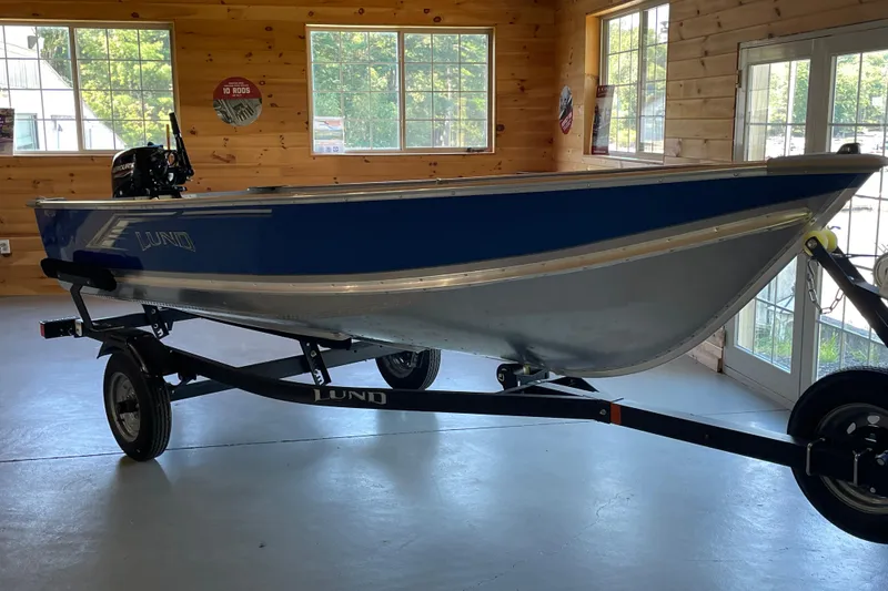 Slide: The Image of 2024 Lund WC 14 Tiller boat on trailer in wooden interior showroom. - 2