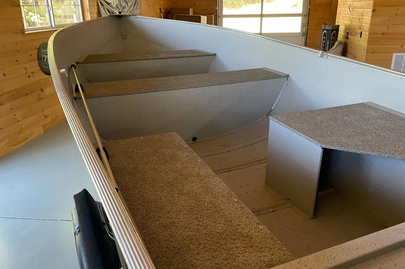 Slide: The Image of 2024 Lund WC 14 Tiller boat interior with seating, in a wooden garage. - 5