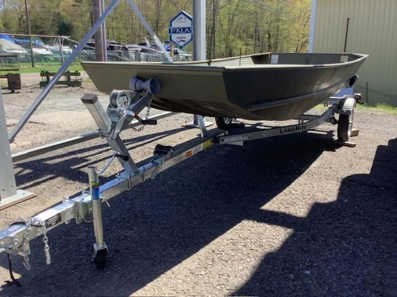 Slide: The Image of 2024 Lund Jon Boat 1448 on a trailer in a boatyard. - 0