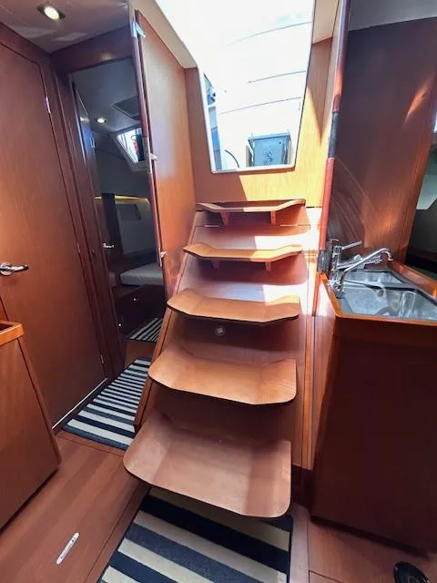 Slide: The Image of 2013 Beneteau 48 yacht cockpit with wooden table and seating at marina. - 10