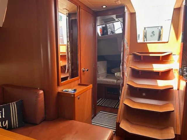 Slide: The Image of Cozy bedroom in 2013 Beneteau 48 sailboat with wooden cabinets and a double bed. - 11