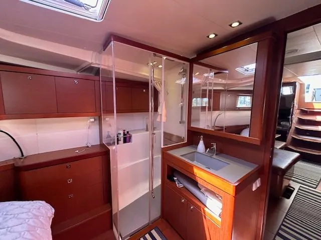 Slide: The Image of 2013 Beneteau 48 yacht bathroom with modern fixtures and wooden cabinetry. - 26
