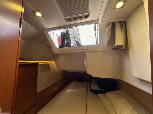 Slide: The Image of Cozy cabin interior of 2013 Beneteau 48 sailboat with double bed and wooden furnishings. - 35
