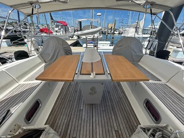 Slide: The Image of Beneteau 48 (2013) sailboat cockpit with covered seating and wooden deck at marina. - 7