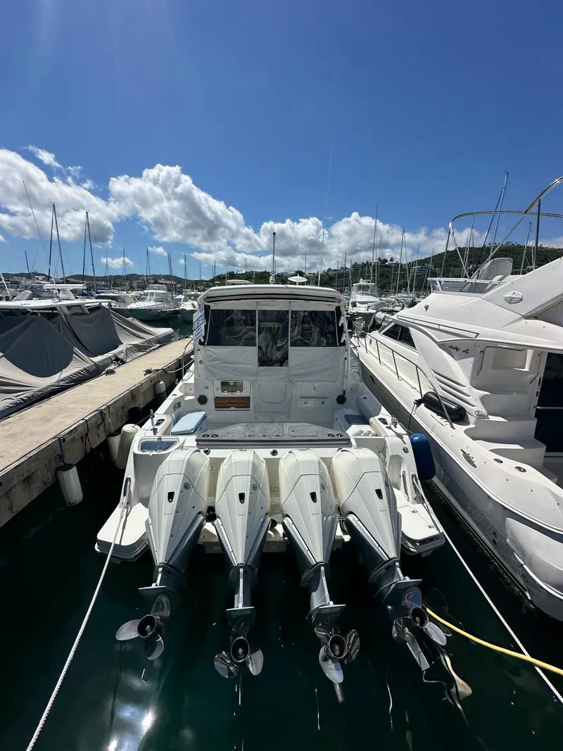 The Image of 2021 Boston Whaler 405 Conquest docked at marina under clear blue sky. - 0