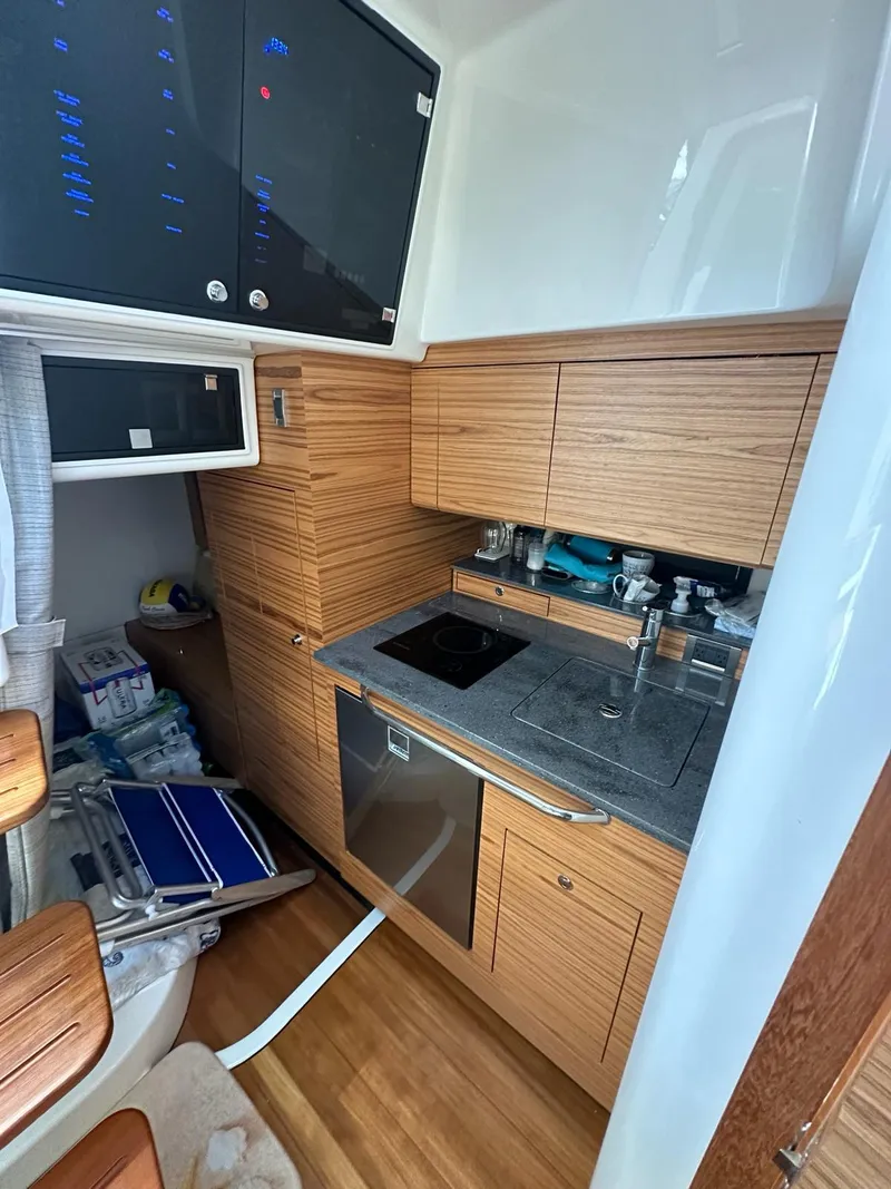 Slide: The Image of 2021 Boston Whaler 405 Conquest kitchen with wood cabinetry and modern appliances. - 10