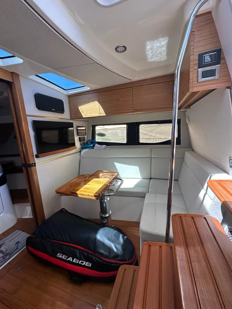 Slide: The Image of Interior of 2021 Boston Whaler 405 Conquest, featuring modern seating and a compact table. - 11
