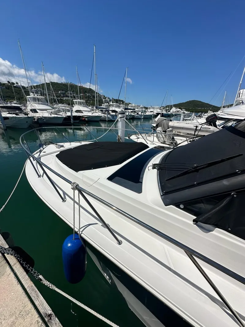 Slide: The Image of 2021 Boston Whaler 405 Conquest docked in a marina under clear blue skies. - 2