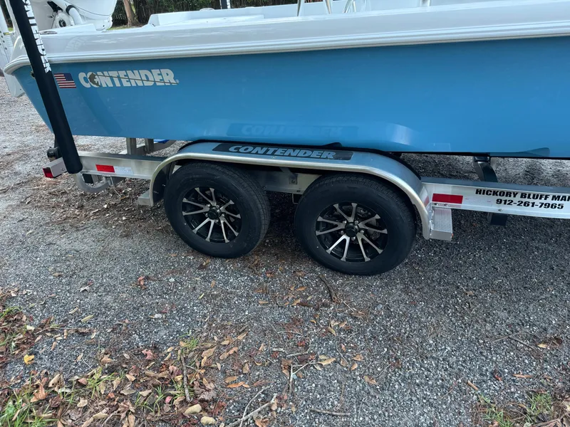 Slide: The Image of 2024 Contender 23 Bay boat on trailer with dual axles and black alloy wheels. - 14