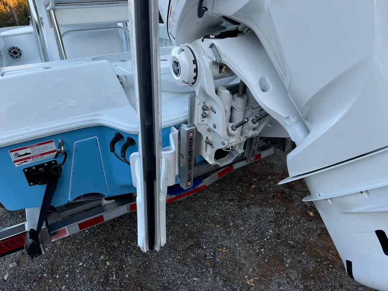 Slide: The Image of 2024 Contender 23 Bay boat on trailer, showcasing engine and hull details. - 15