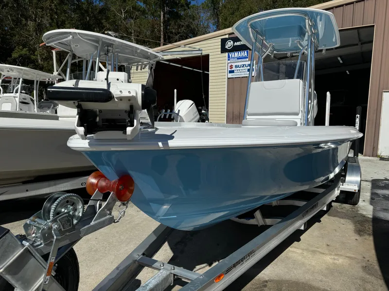 Slide: The Image of 2024 Contender 23 Bay boat on trailer, displayed outdoors near a dealership. - 19