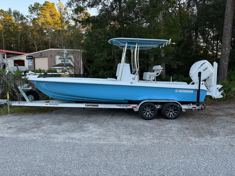 Slide: The Image of 2024 Contender 23 Bay boat on trailer, parked outdoors. - 2