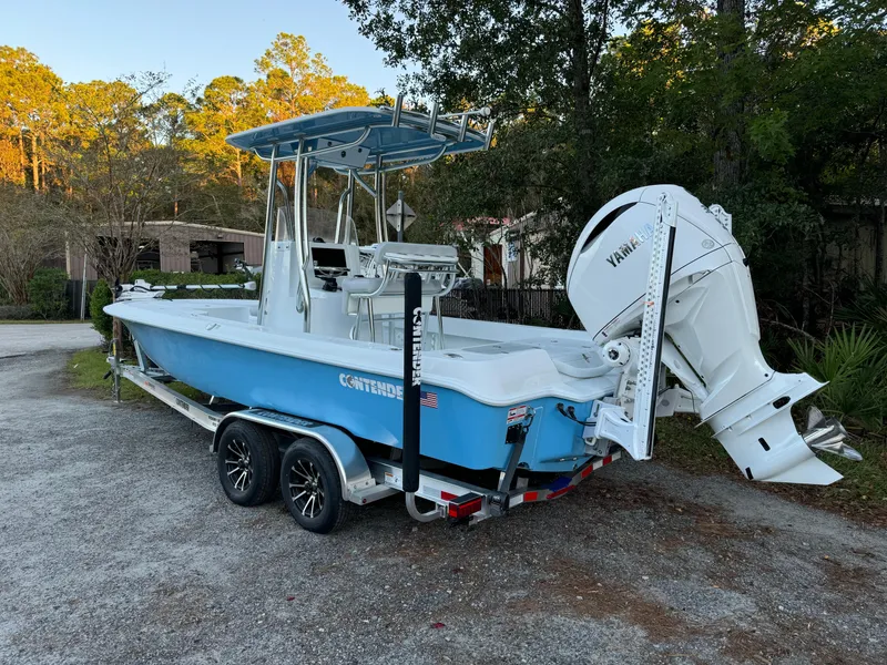 Slide: The Image of 2024 Contender 23 Bay boat with Yamaha engine on trailer, parked outdoors. - 3