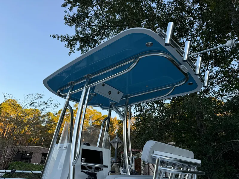 Slide: The Image of 2024 Contender 23 Bay boat with blue T-top and rod holders. - 6