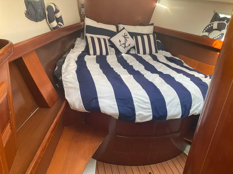 Slide: The Image of Cozy cabin interior of 2005 Beneteau Oceanis 473 with nautical-themed bedding. - 11