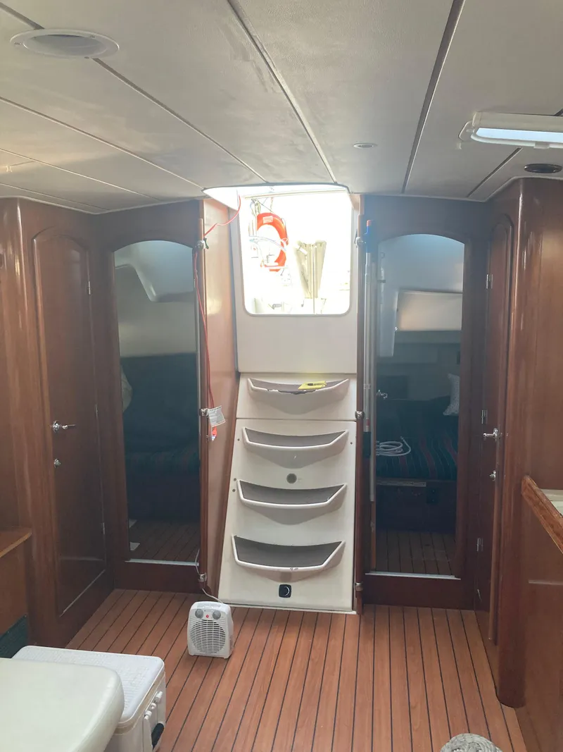 Slide: The Image of Interior of 2005 Beneteau Oceanis 473 sailboat with wooden flooring and cabin doors. - 14