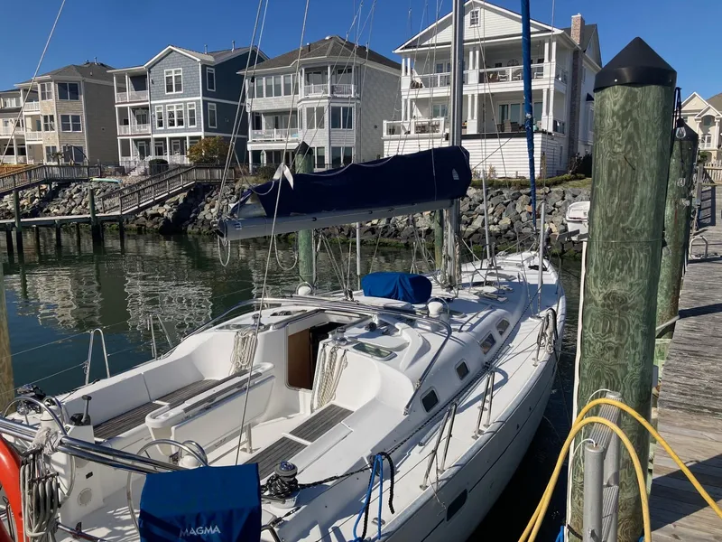 Slide: The Image of Beneteau Oceanis 473 sailboat docked at marina, surrounded by waterfront homes. - 5