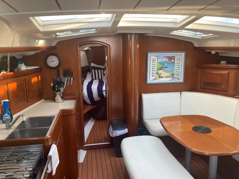 Slide: The Image of Interior of 2005 Beneteau Oceanis 473 yacht with cozy seating and wooden finishes. - 6