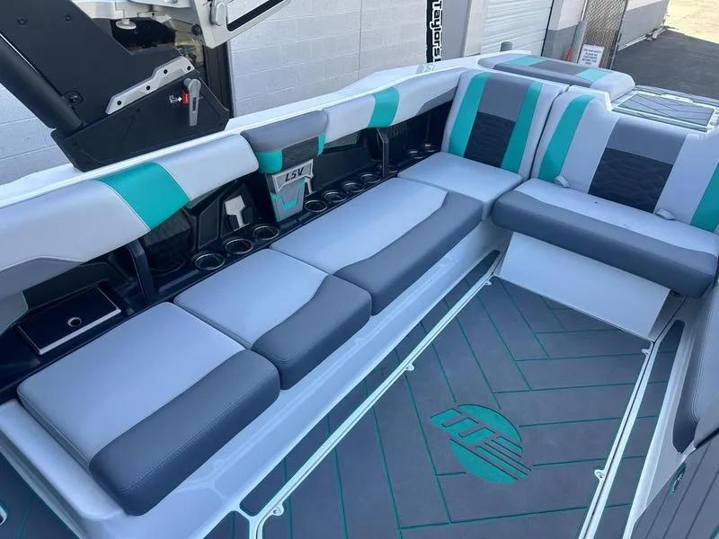 Slide: The Image of 2023 Malibu 26 LSV boat interior with gray and teal seating. - 11