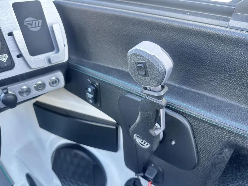 Slide: The Image of 2023 Malibu 26 LSV boat dashboard with control panel and throttle lever. - 17