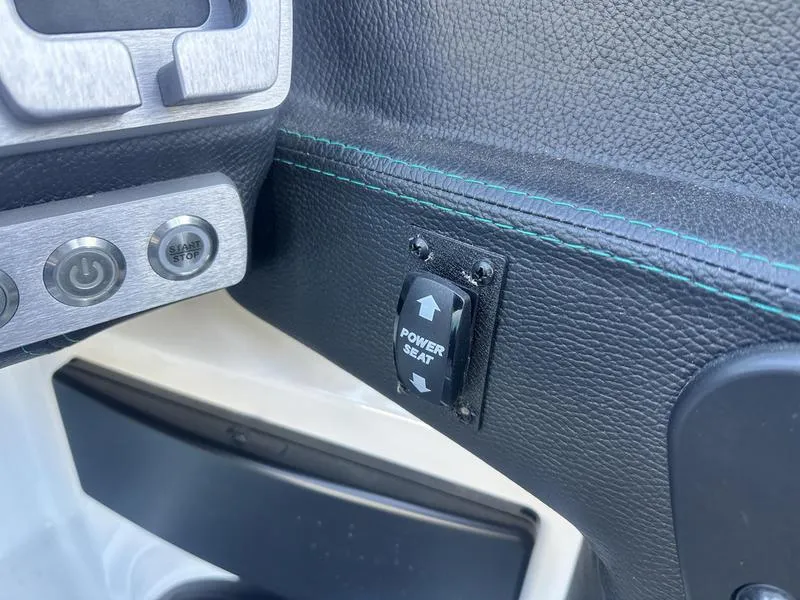 Slide: The Image of 2023 Malibu 26 LSV power seat control panel with buttons and stitching detail. - 19