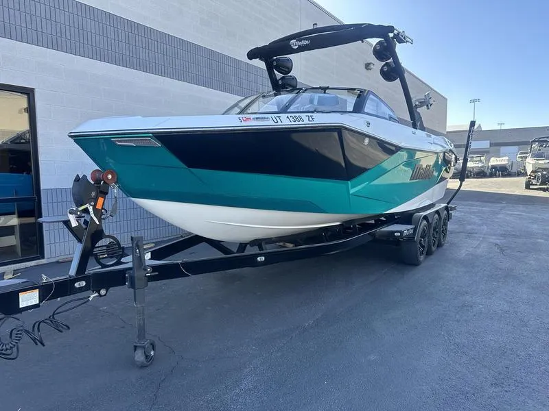 Slide: The Image of 2023 Malibu 26 LSV boat on trailer, parked outdoors. - 4