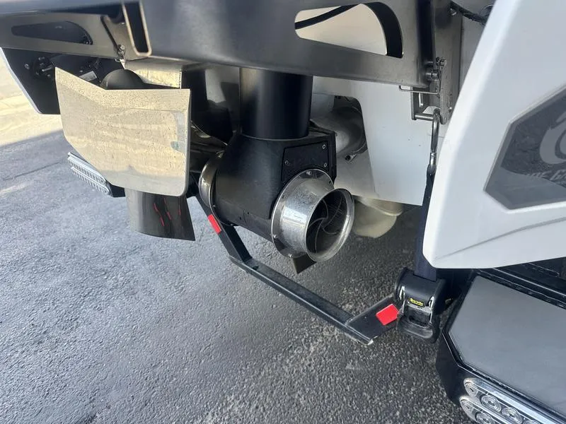 Slide: The Image of 2023 Malibu 26 LSV boat exhaust and propeller detail on a paved surface. - 8
