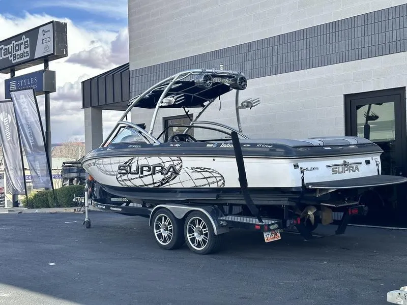 Slide: The Image of 2010 Supra Launch 24V Worlds Edition boat on trailer outside dealership. - 4