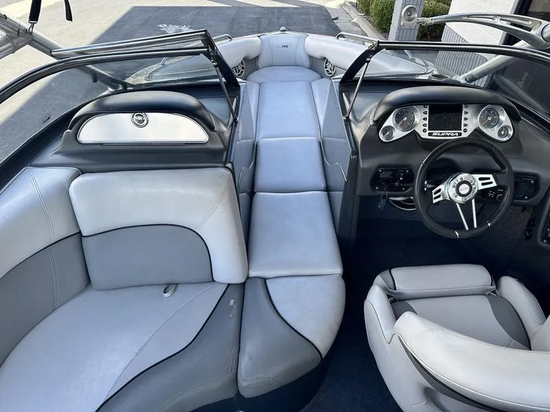Slide: The Image of 2010 Supra Launch 24V Worlds Edition boat interior with gray and white seating. - 9