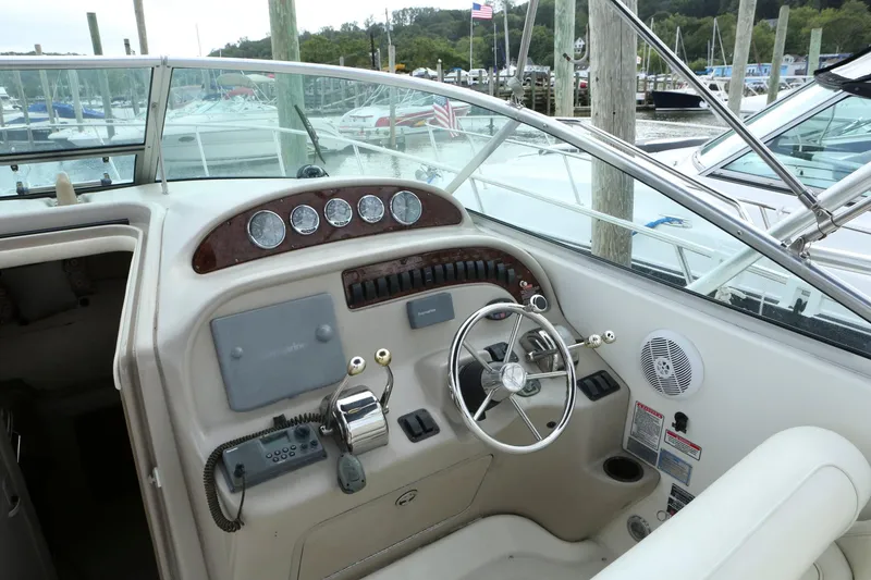 Slide: The Image of 2004 Sea Ray 290 Amberjack boat helm with steering wheel and control panel. - 14