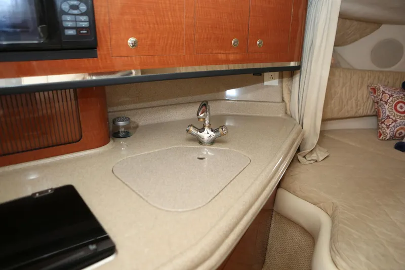 Slide: The Image of 2004 Sea Ray 290 Amberjack interior kitchen sink and countertop area. - 25