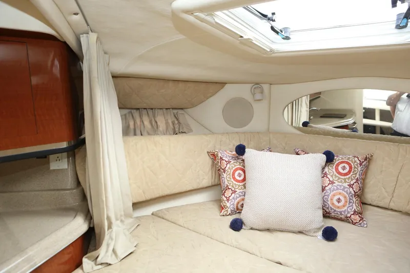 Slide: The Image of Interior cabin of a 2004 Sea Ray 290 Amberjack boat with cozy bedding and decorative pillows. - 30