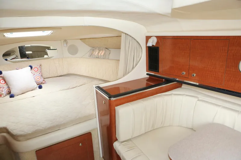 Slide: The Image of 2004 Sea Ray 290 Amberjack cabin interior with bed, seating, and wooden cabinetry. - 31