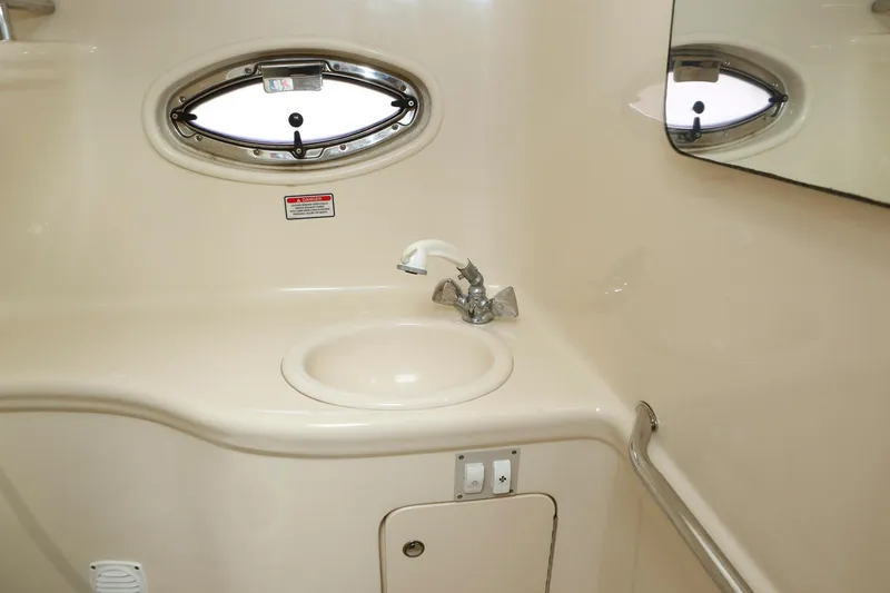 Slide: The Image of 2004 Sea Ray 290 Amberjack bathroom sink with oval porthole and mirror. - 35