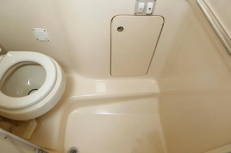Slide: The Image of 2004 Sea Ray 290 Amberjack bathroom with toilet and storage compartment. - 36