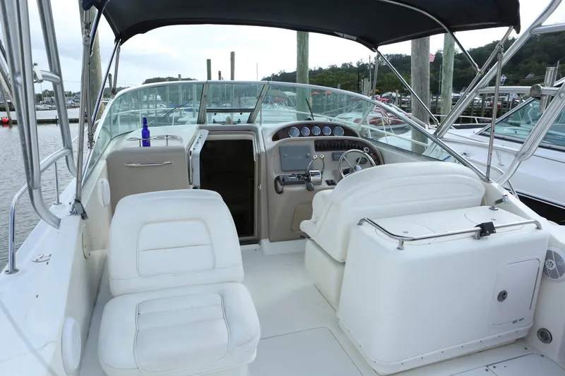 Slide: The Image of 2004 Sea Ray 290 Amberjack boat interior with white seating and control panel. - 4
