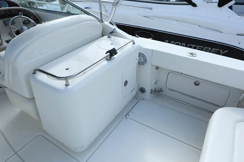 Slide: The Image of 2004 Sea Ray 290 Amberjack boat interior with white seating and storage compartments. - 6