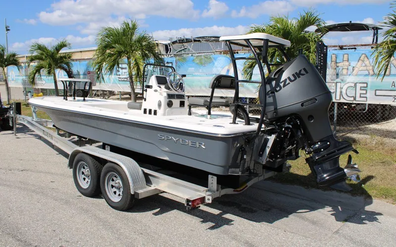 Slide: The Image of 2024 Spyder FX19 Vapor boat on a trailer with Suzuki outboard motor. - 2