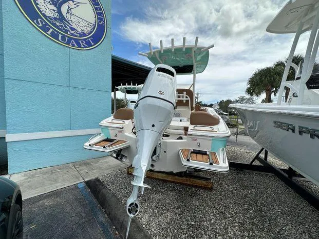 Slide: The Image of 2024 Pioneer 202 Islander boat displayed at a dealership, rear view with outboard motor. - 3